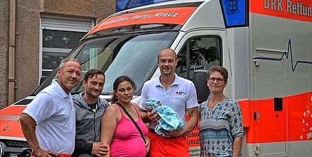 Die Notfallsanitäter Luis Scholl (links) und Marco Klein freuen sich mit den Eltern des kleinen Alexander-Damian und Hebamme Petra Walczok über die glückliche Geburt im Rettungswagen. Foto: Matthias Böhl