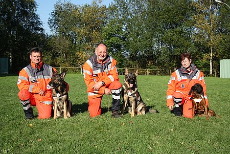 Bestanden jetzt die DRK-Rettungshundeprüfung: Andreas von Bülow mit Paika, Günter Scheid mit Gloria (beide Fläche) und Brigitte von Szczawinski mit Mantrailer Heidi (v.l.) vom DRK-Kreisverband Siegen-Wittgenstein. Bildrechte: DRK-Kreisverband Siegen-Wittgenstein e.V.