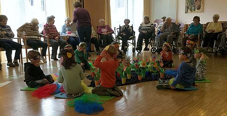 Die Leseeulengruppe aus dem DRK-Familienzentrum Weltenbummler inmitten der Fliedner-Heim Bewohner