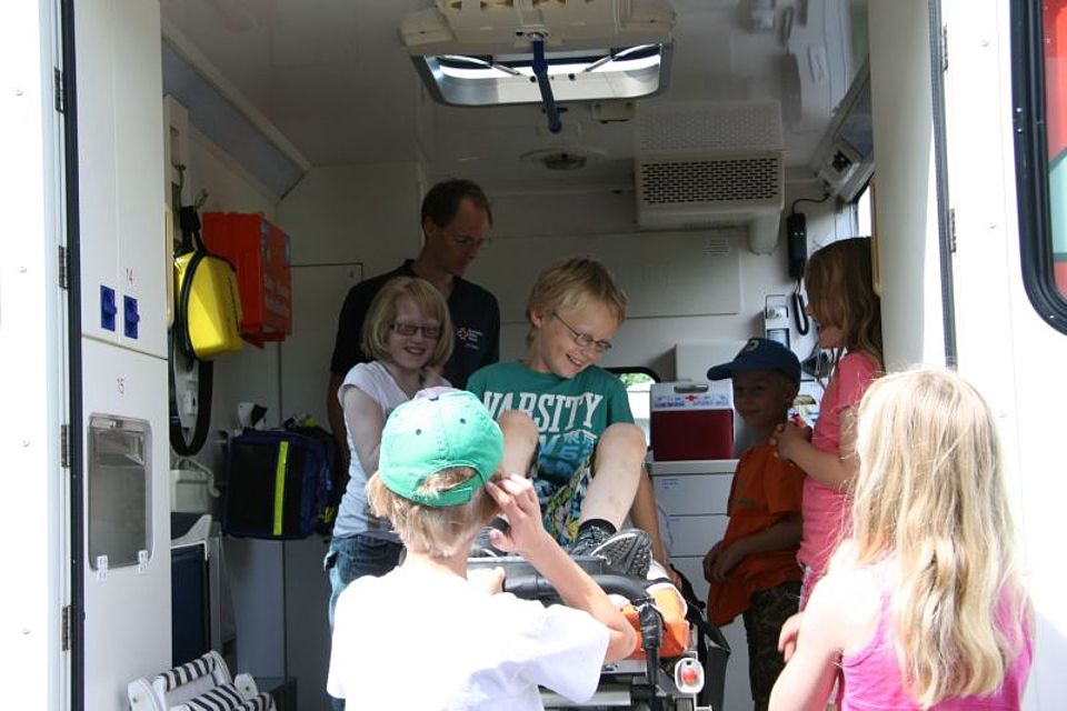 Die Kinder der Ferienspiele bekommen durch DRKler Christoph Enter (hinten) einen Krankenwagen erklärt und gezeigt.