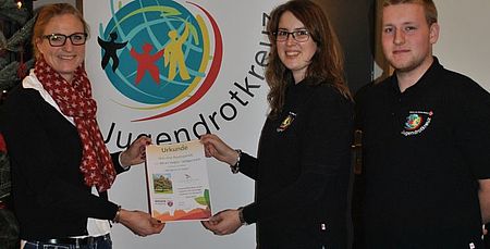 vl. Stadtmitarbeiterin Frau Ihlenfeld übergibt das Baumzertifikat an Melanie Graf und Mike Neeb vom Jugendrotkreuz