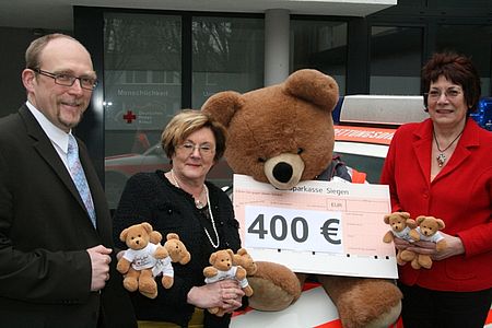 vl.: Ralf Henze (DRK-Kreisgeschäftsführer) erhält von Eva-Marie-Bialowons-Sting (Vorsitzende Aktive-Frauen Siegen) und Erika Stei (Geschäftsführerin der Aktiven-Frauen Siegen) einen Scheck über 400 Euro für dringend benötigte neue Rettungsteddys.