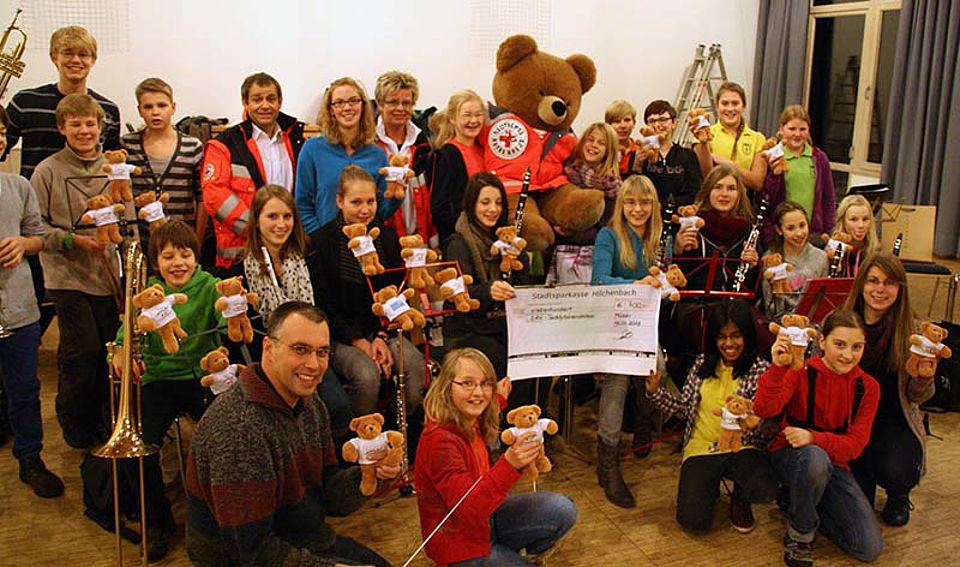 Dirk Setzer als Dirigent des Jugendorchesters des Musikvereins Müsen 1919 eV. (kniend vorne links) übergab bei der Orchsterprobe im Bürgerhaus Müsen eine Spende von 700 Euro an Rüdiger Schmidt (Leiter DRK-Rettungsdienst/Krankentransport, letzte Reihe 5. vl) und Ute Heß (Wachleiterin DRK-Rettungswache Kreuztal, letzte Reihe 7. vl)