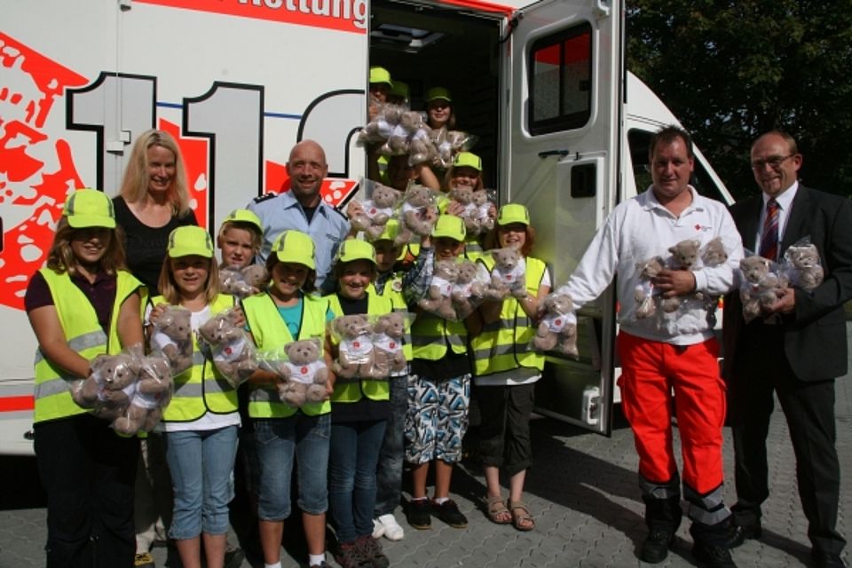 vl: Lehrerin Hannah Weissiger und Polizist Ralf Möckel (hinten), übergeben gemeinsam mit den Schülern der Stahlbergschule insgesamt 50 Rettungsteddys an Detlef Klein (stellv. Wachleiter der Rettungswache Kreuztal) und Ralf Henze (DRK-Kreisgeschäftsführer)